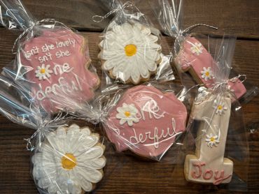 Decorated cookies with joyful messages and floral designs.