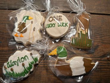 Golf-themed decorated cookies wrapped in plastic.