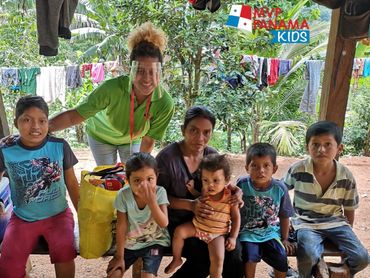 A group of children and two adults gathered outdoors with a banner reading MVP Panama Kids.