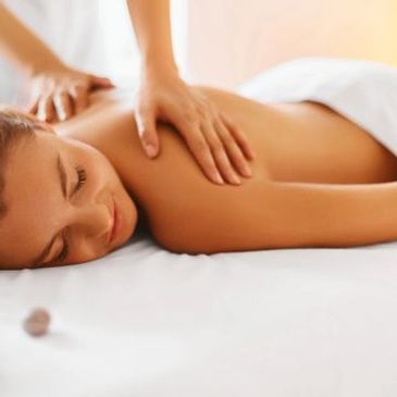 A woman receiving a relaxing back massage in a spa setting.