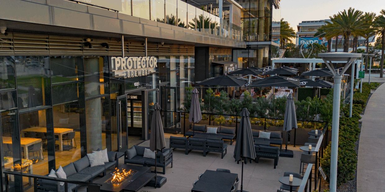 Outdoor seating area of Protector Brewery with cozy fire pits and umbrellas.