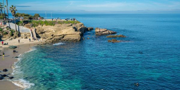 Scenic coastal view with a rocky cliff and clear blue ocean water.