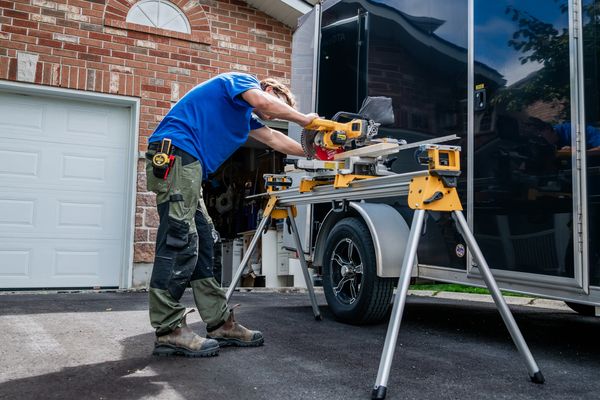 Man using a miter saw outdoors.
