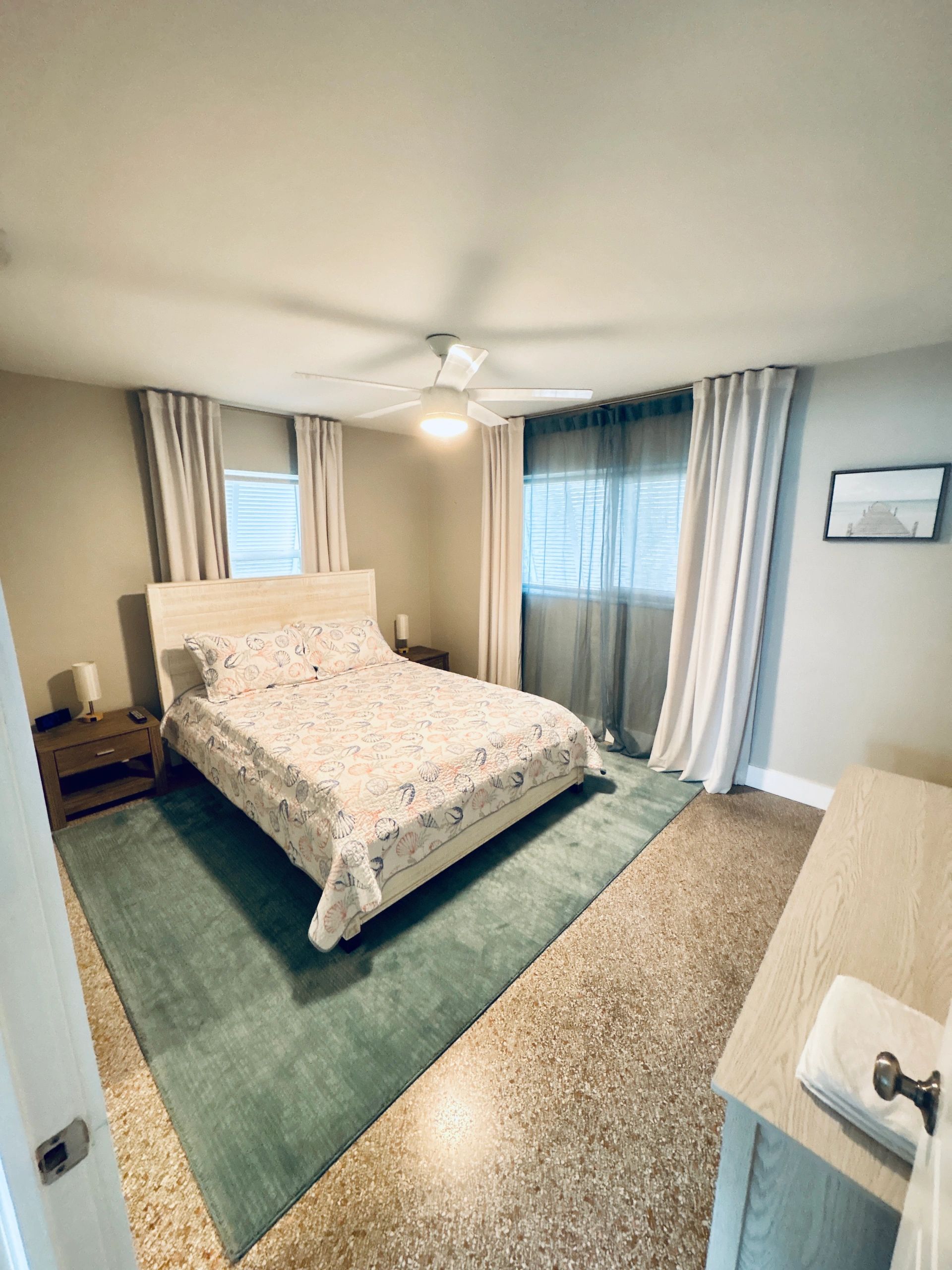 Cozy bedroom with seashell-themed bedding and soft lighting.