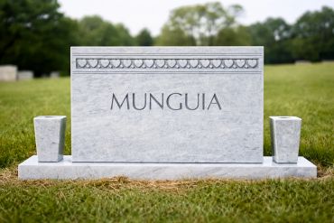 A white marble gravestone with the name Munguia.