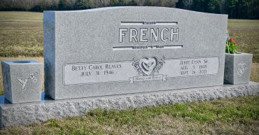 Gray tombstone for the French family in a cemetery.