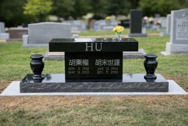 Black granite gravestone with the name HU and dates.