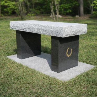 Granite memorial bench with a horseshoe design.
