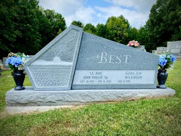 A double grave headstone with floral decorations on both sides.
