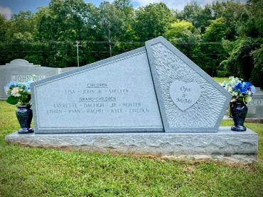 Memorial headstone with engraved family names and dates.