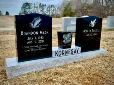 Dual gravestones of Brandon Mark and Ashley Russell in a rural cemetery.