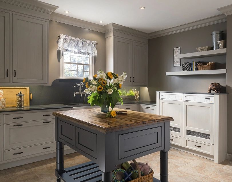 Cozy kitchen with gray cabinets, wooden island, and a bouquet of sunflowers.