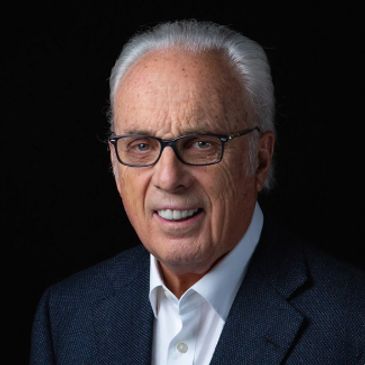 Portrait of elderly man with white hair and glasses.