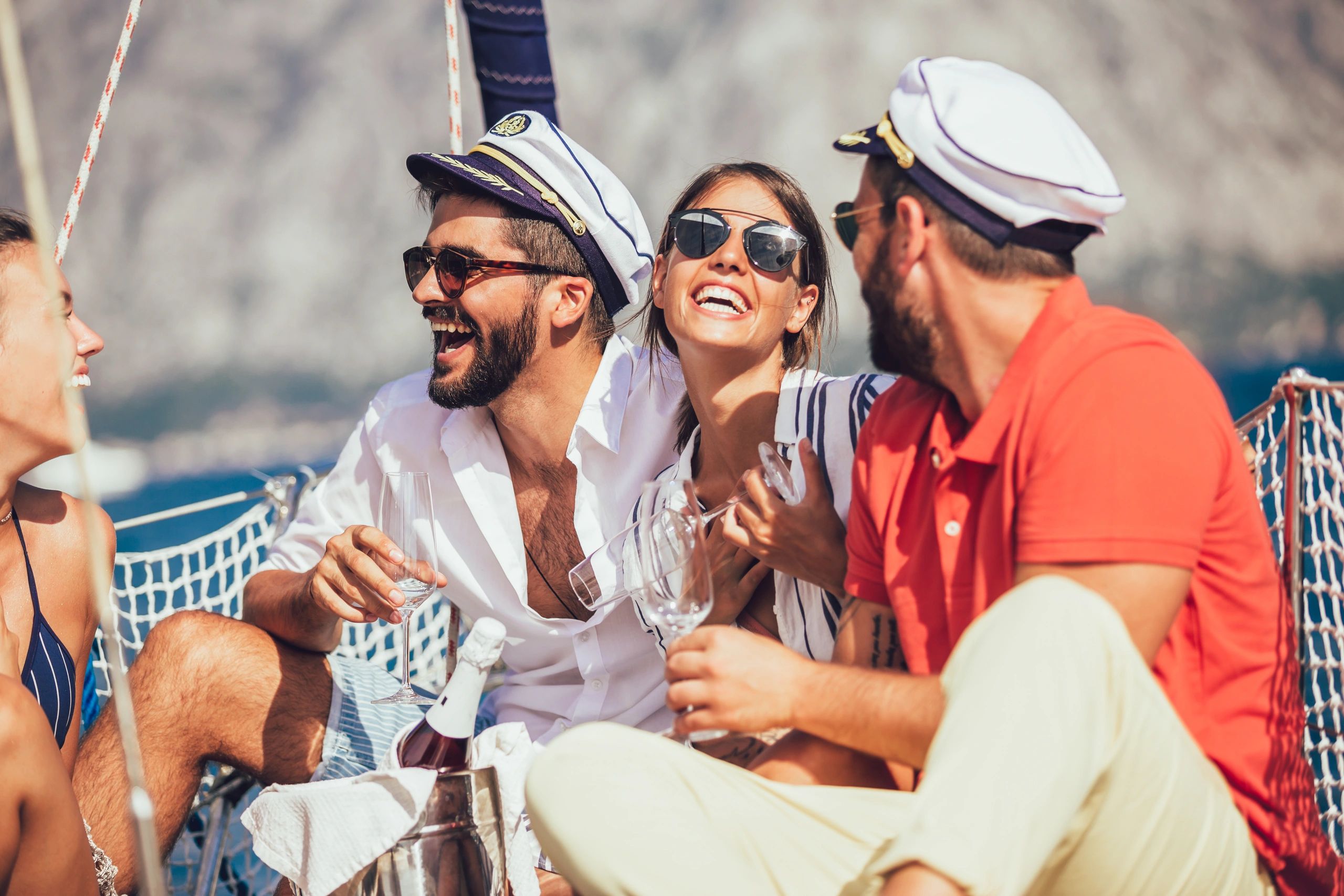 Group of friends enjoying a yacht party, laughing and drinking.