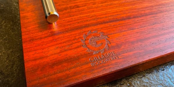 Close-up of wooden board with Gilagame Woodworks logo.