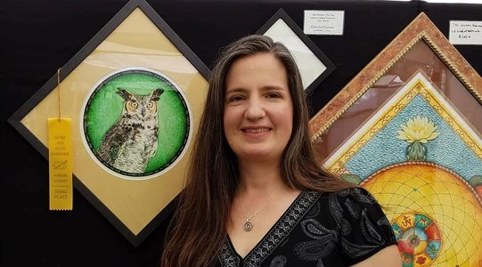 Heather next to her award winning great horned owl watercolor mandala.