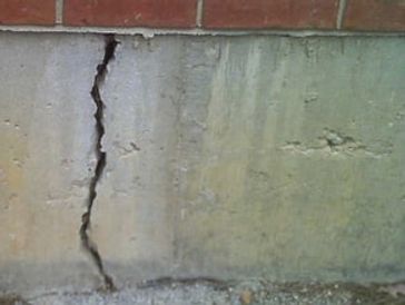 Cracked foundation concrete slab in need of repair or inspection by licensed engineer.