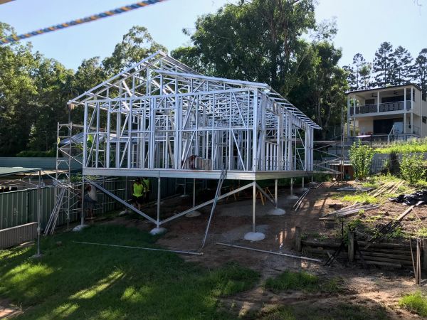 Steel frame structure of a house under construction on stilts.