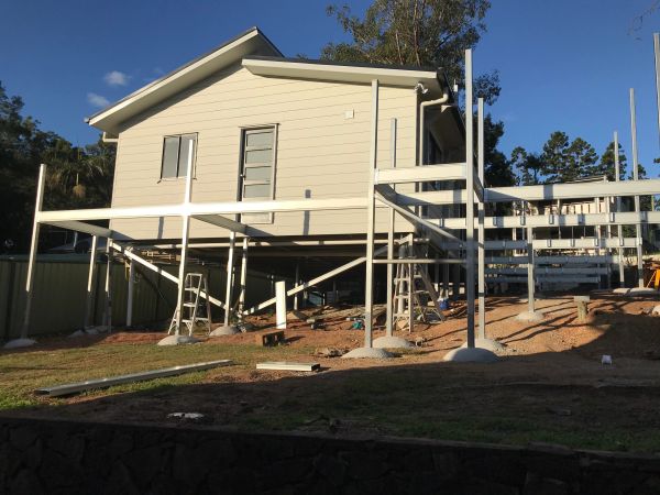 House elevated on stilts with ongoing construction around it.