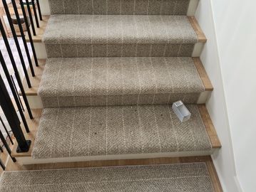 Carpeted stairs with a small white object on one step.