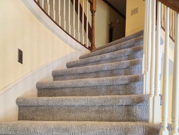 Carpeted staircase with beige and gray tones in a home interior.