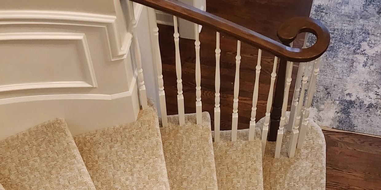 Beautifully carpeted stairs with wooden handrail, installed by Flooring It KC in Liberty, MO