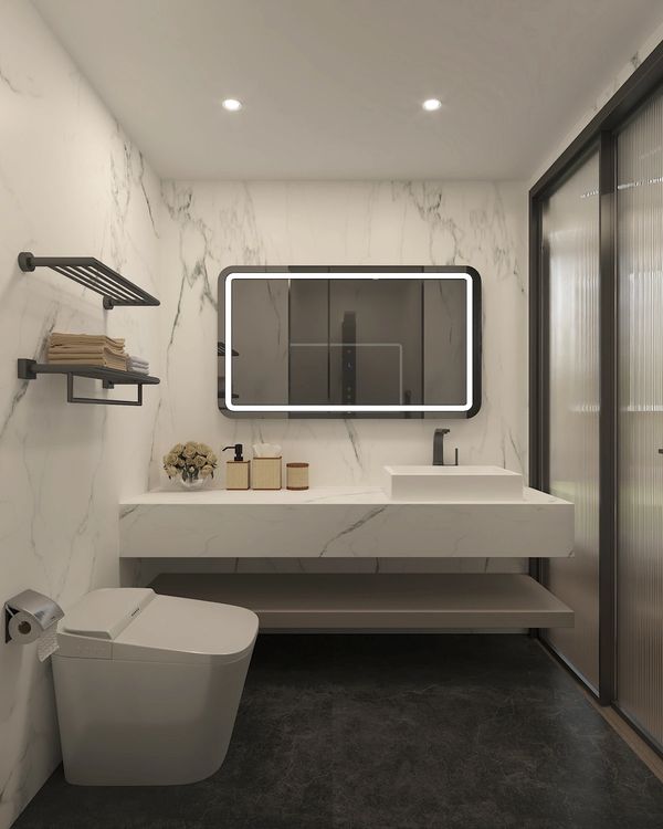 Modern bathroom with marble walls, illuminated mirror, and sleek fixtures.