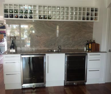Modern kitchen with wine storage and appliances.