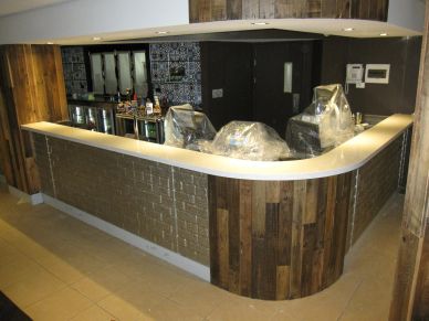 Indoor modern bar with dark wood and plastic-covered chairs.