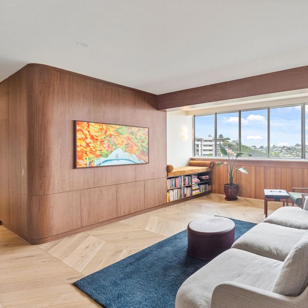 Bright living room with large windows and wooden paneling.