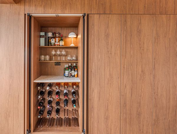 Wooden cabinet with wine and liquor bottles.