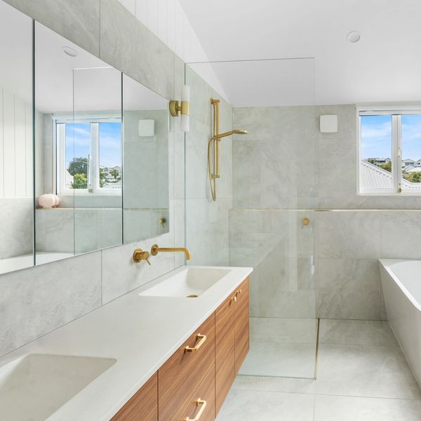 Modern bathroom with double sinks and glass shower.