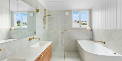 Modern bathroom with bathtub and large mirror.