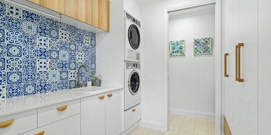 Modern laundry room with blue patterned tile backsplash.