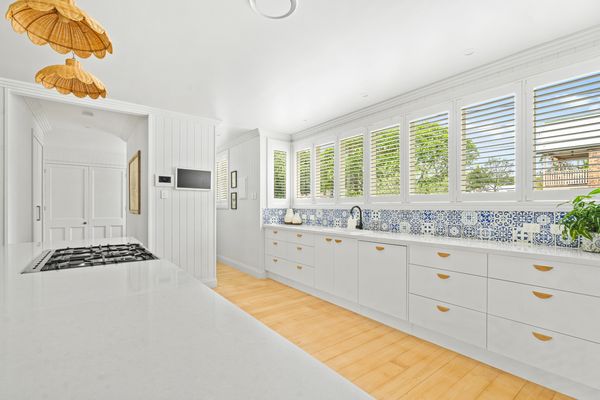 Bright kitchen with white cabinets and patterned backsplash.