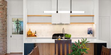 Modern kitchen with blue cabinets and wooden accents.