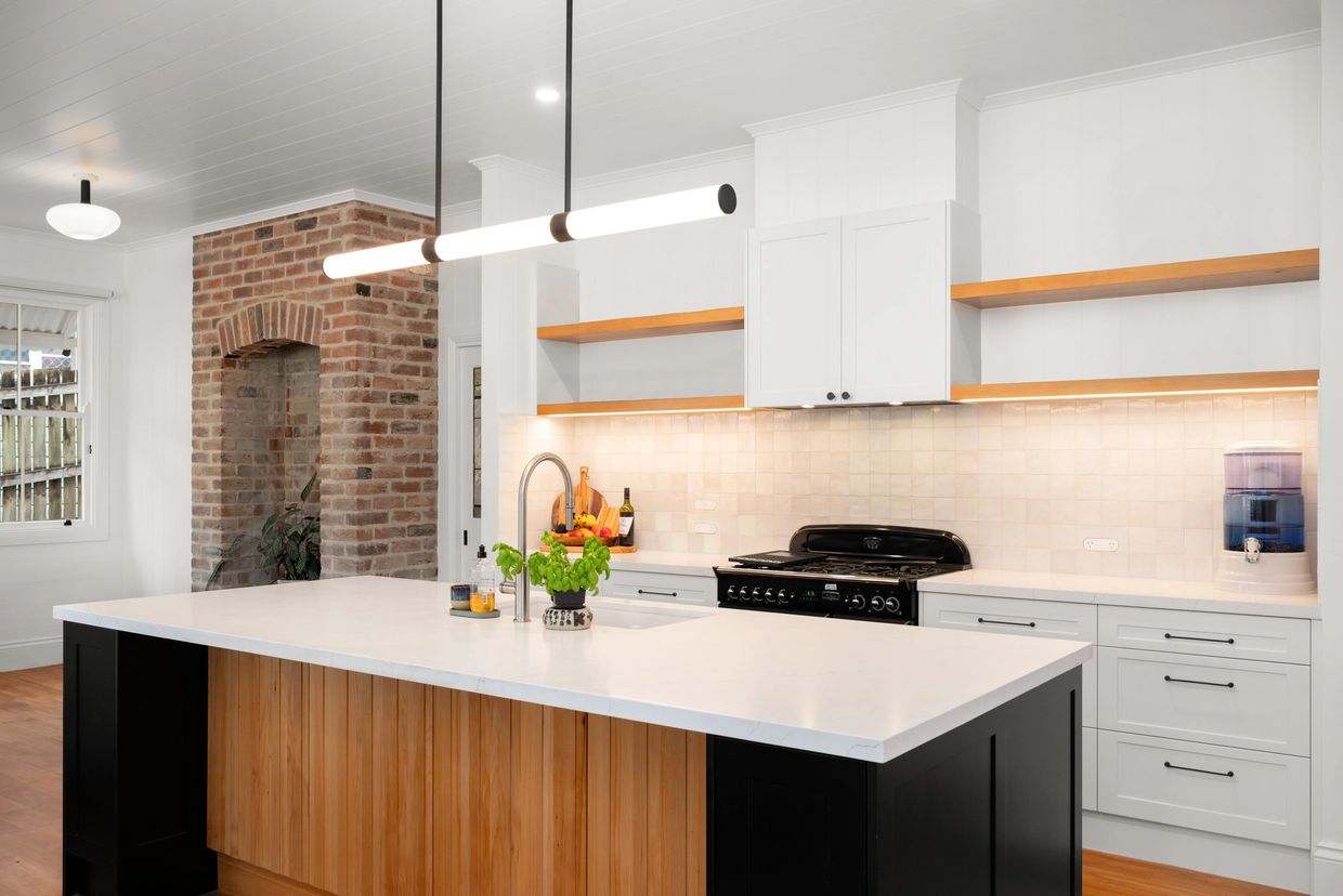 Modern kitchen with a large island and brick accent wall.