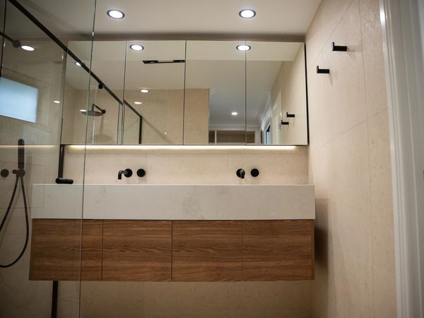 Modern bathroom with wooden vanity and double sink.