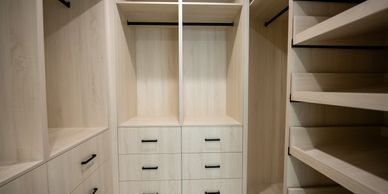 Modern empty wooden closet with drawers and shelves.
