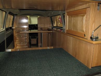 Interior of a compact wooden camper van.