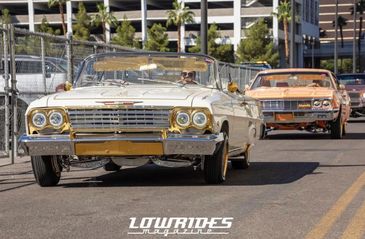 Classic lowrider cars cruising on a sunny day.