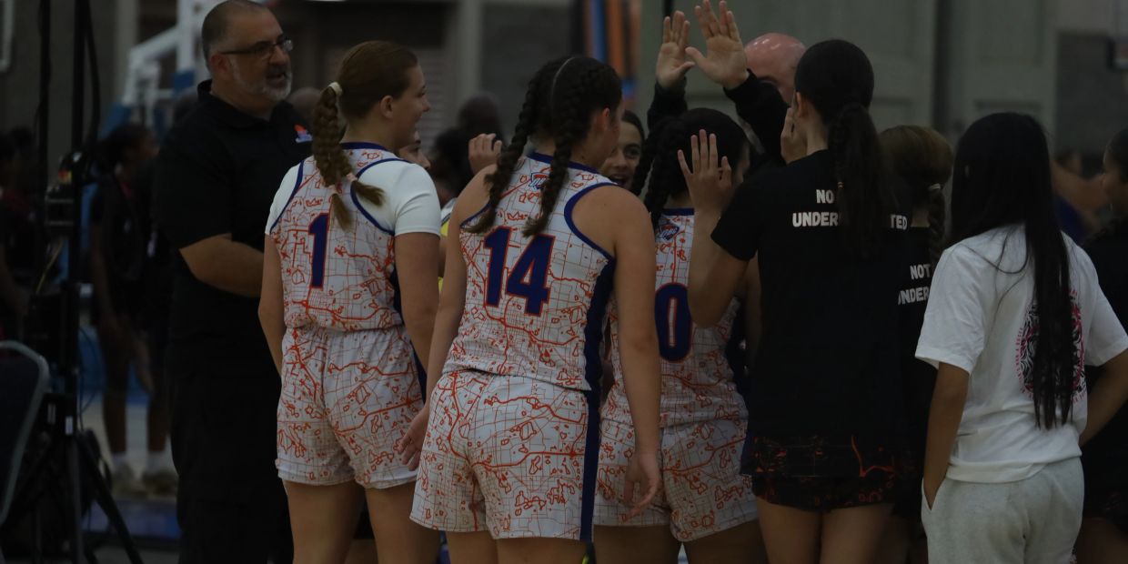 Girls basketball team celebrating a win with high-fives.