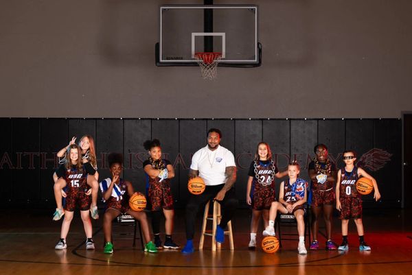 Youth basketball team with coach posing on court.
