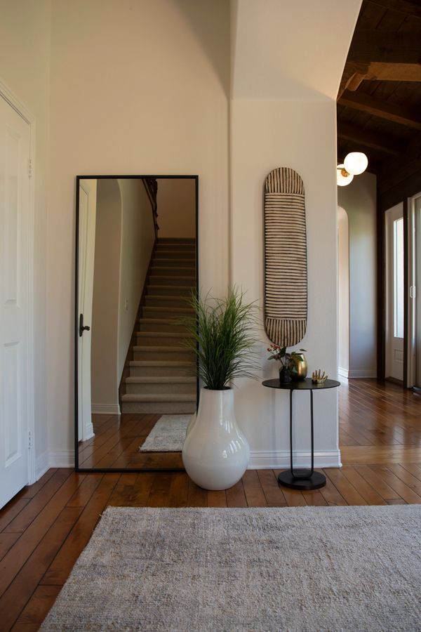 Image of mirror, plant, table and art