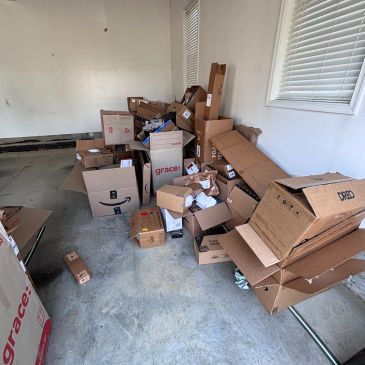 A cluttered pile of various cardboard boxes in a garage.