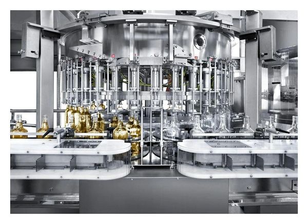 Automated bottling machine filling bottles with liquid.