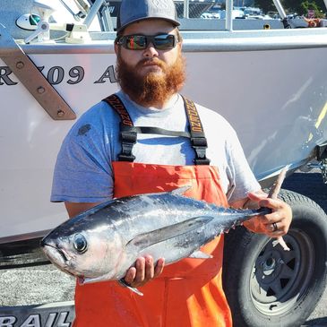 fisherman with a tuna after a charter fishing guide trip from coos bay oregon on the oregon coast