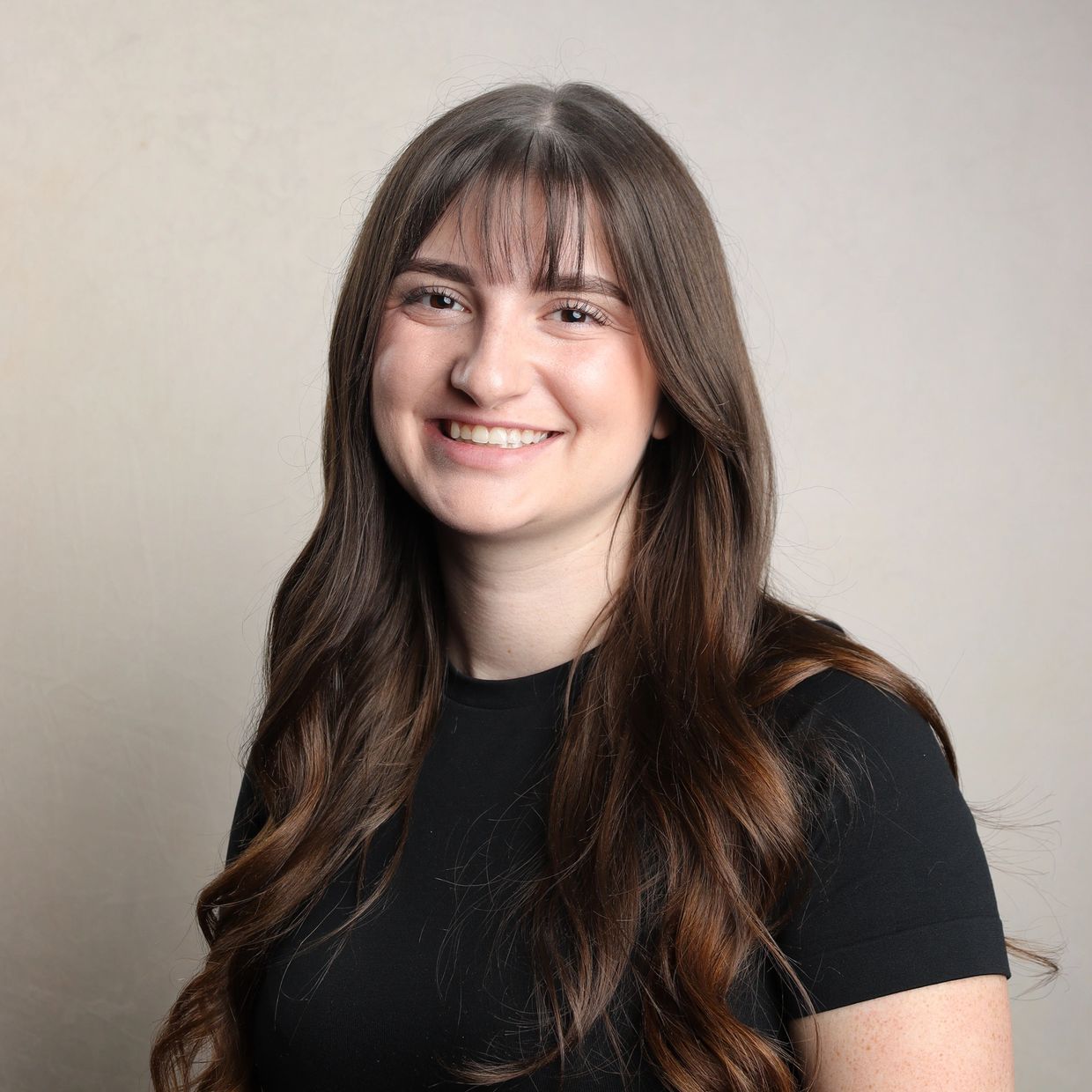 Young woman smiling with long brown hair.