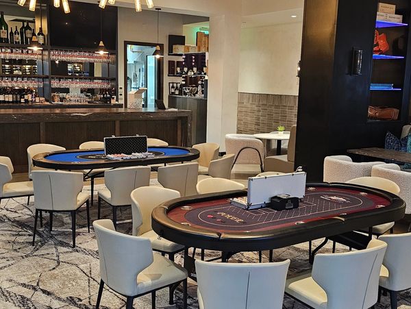 Luxurious game room with poker tables and modern lighting.