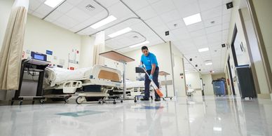 Person cleaning hospital floor with a mop.